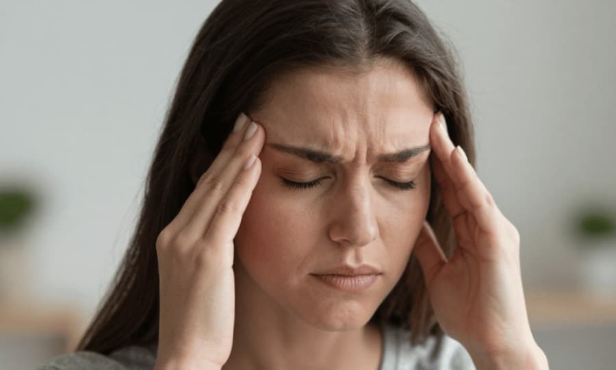Woman holding her temples during a headache