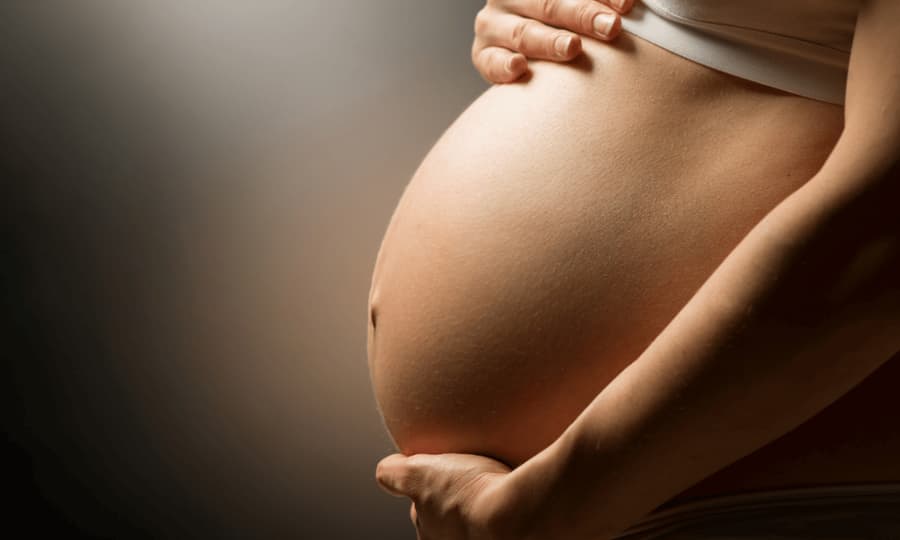Expecting mother cradling her pregnancy bump