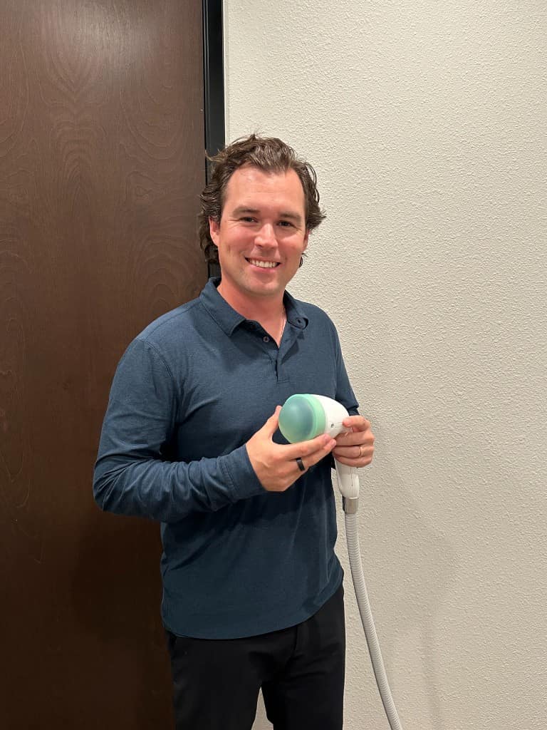 Dr. Brock Martin holding a shockwave therapy device at Martin Chiropractic